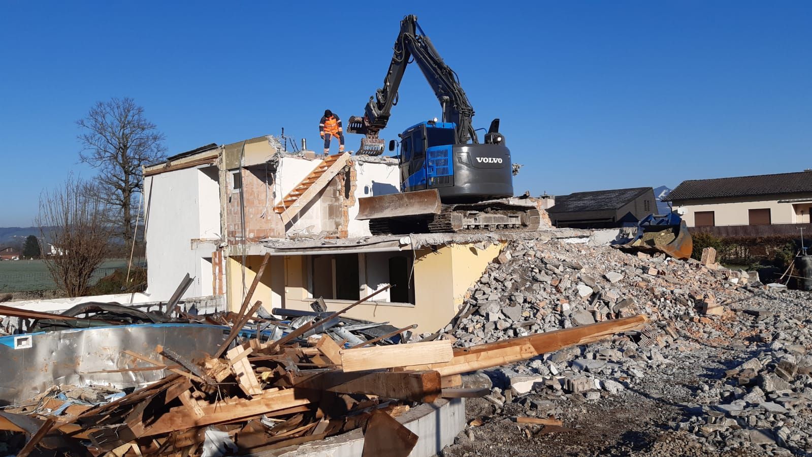 Ein Haus wird von einer Planierraupe abgerissen.