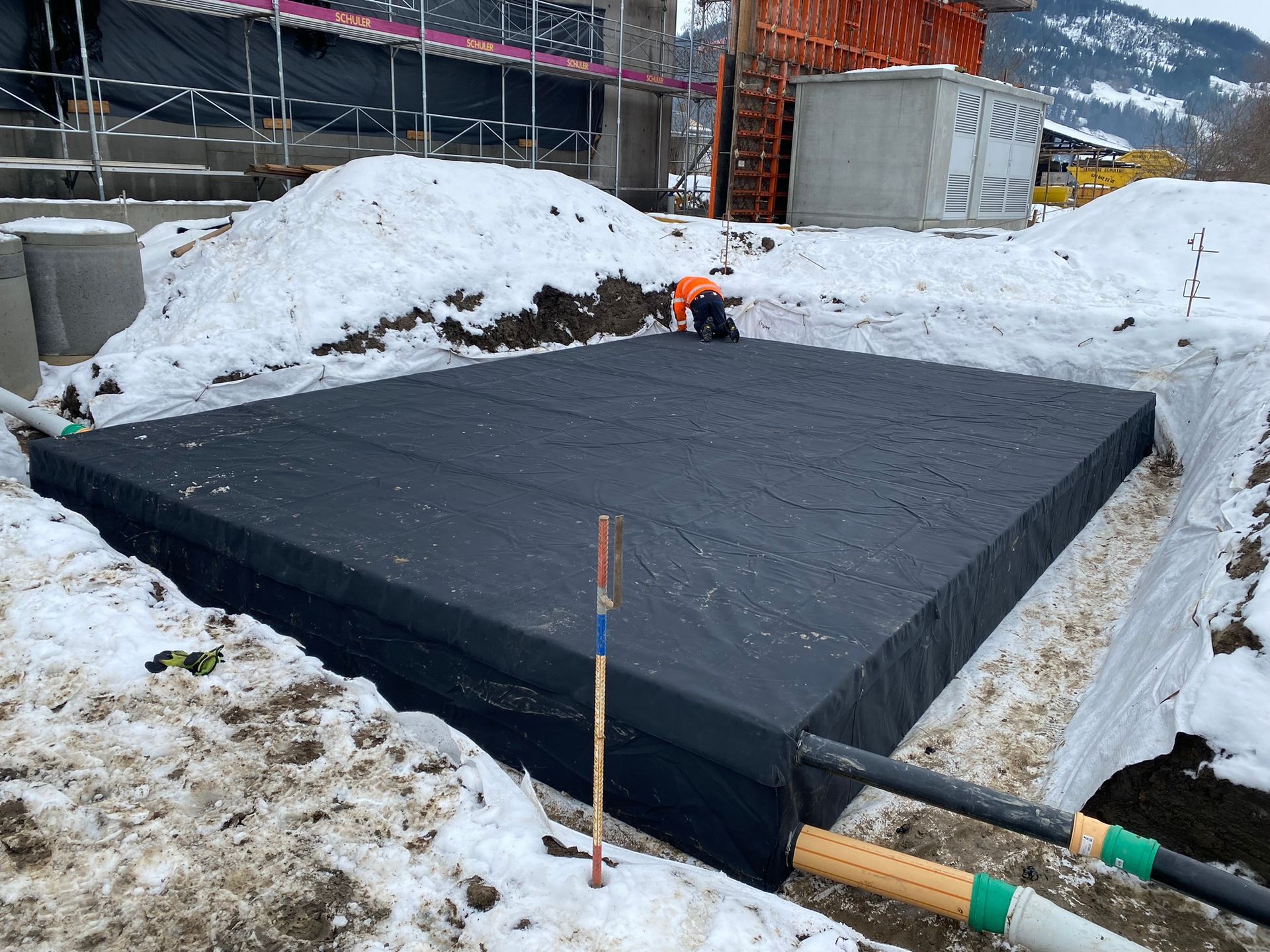 Ein großes schwarzes Quadrat befindet sich inmitten eines schneebedeckten Feldes.