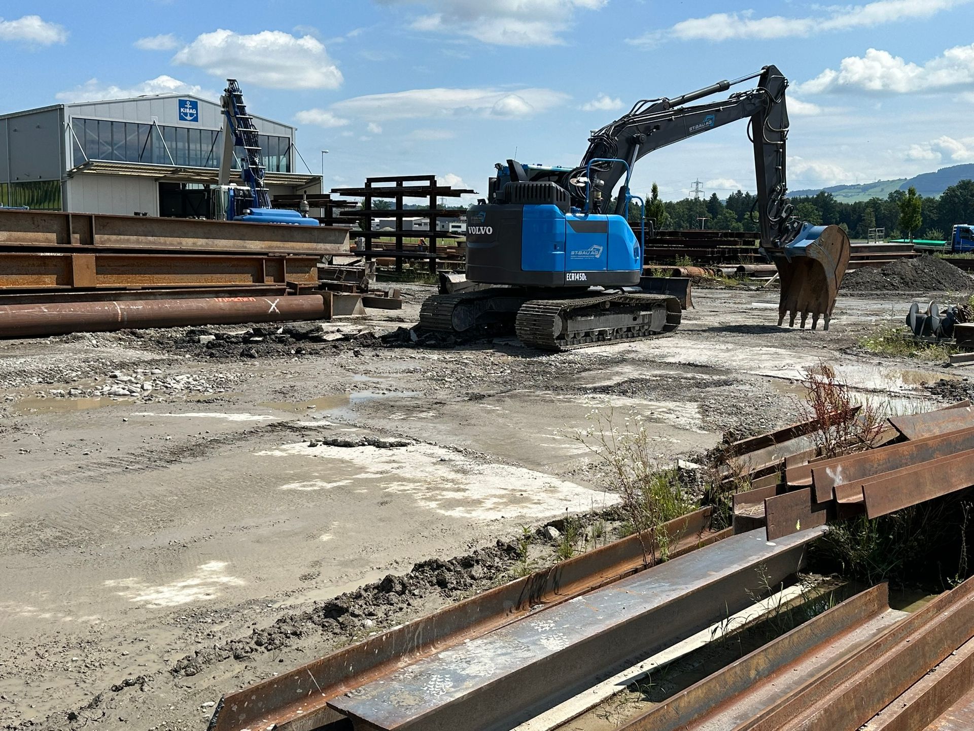 Eine Baustelle mit einem blauen Bagger in der Mitte