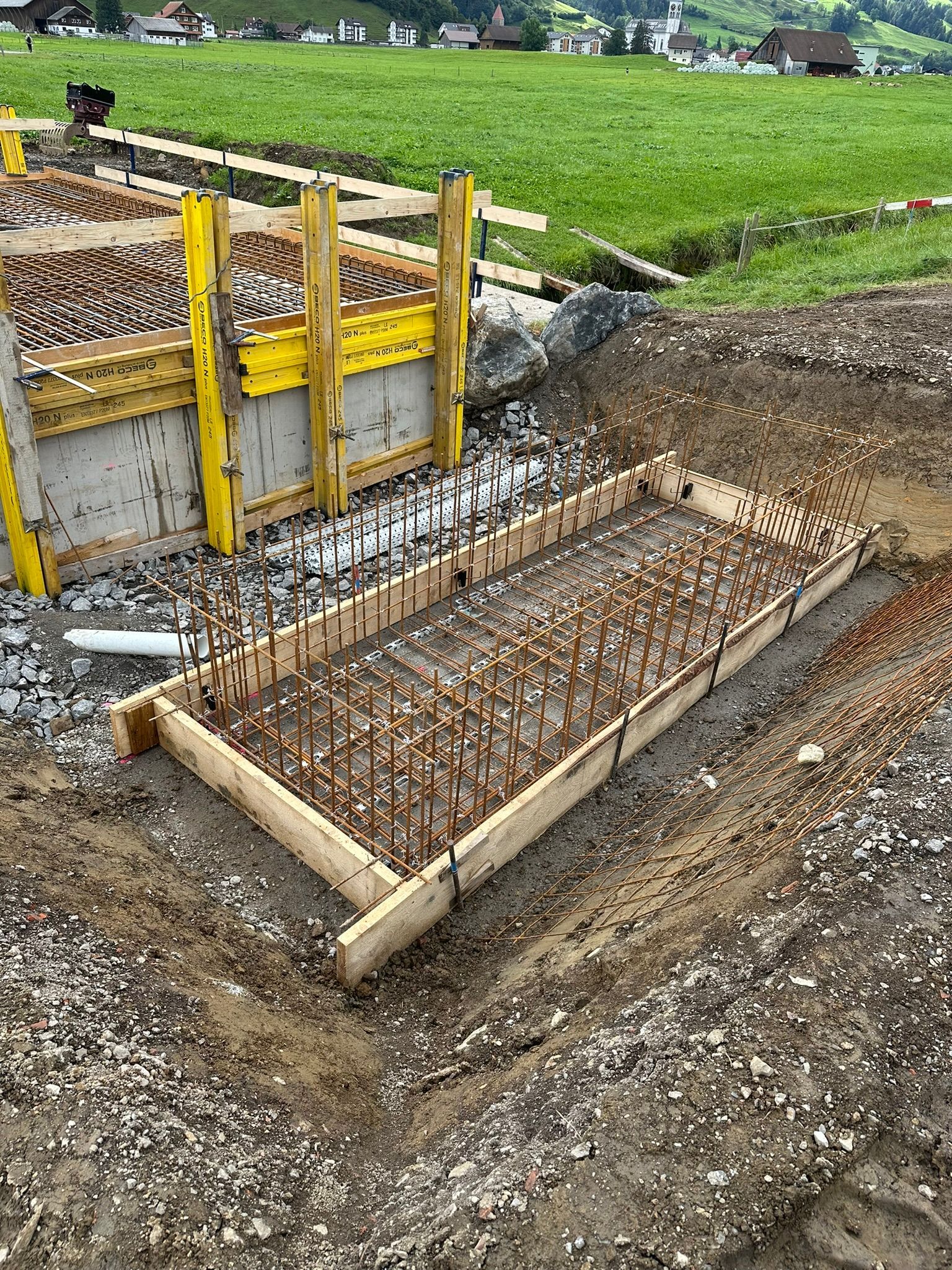 Eine große Holzkiste steht mitten auf einem Feld.