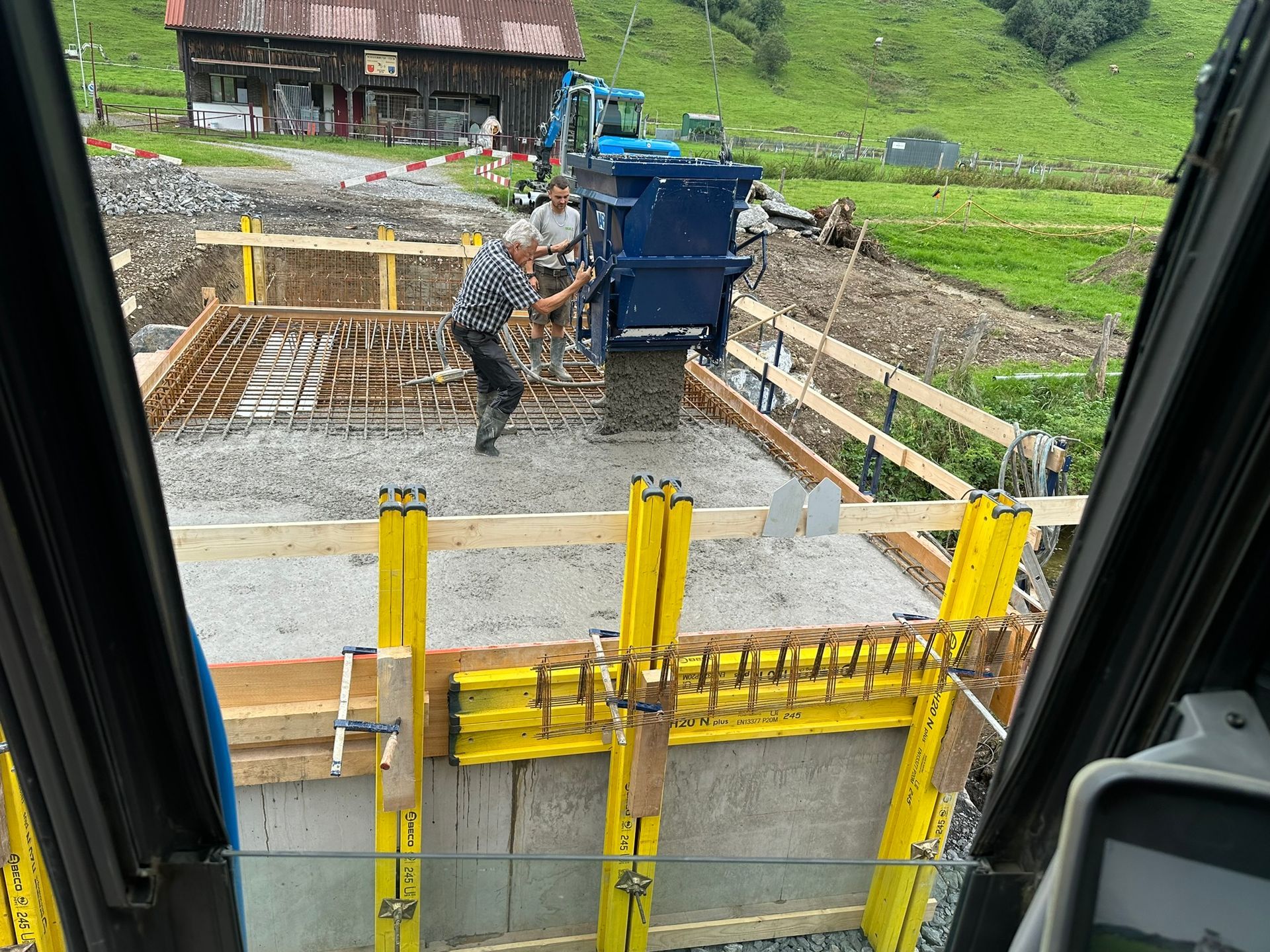 Ein Mann arbeitet auf einer Baustelle mit einer Betonpumpe.