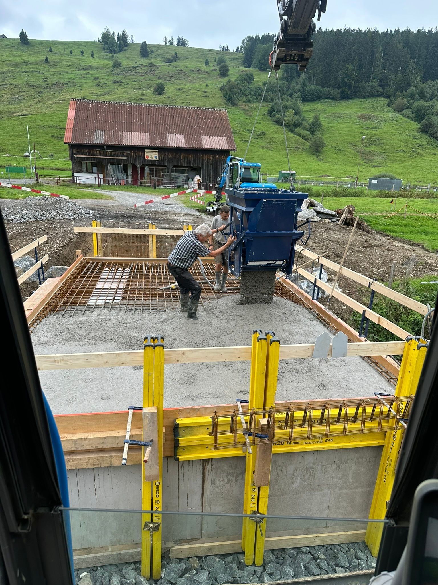 Ein Mann gießt Beton auf einer Baustelle.