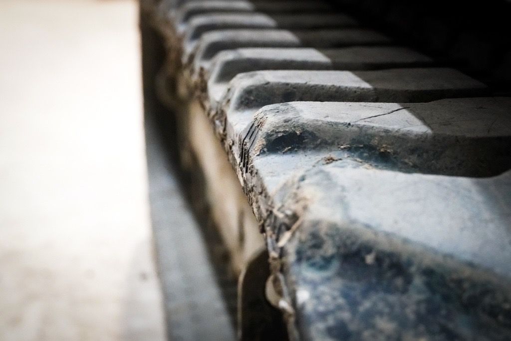 Ein blau-schwarzer Bagger steht auf einem Erdhaufen.