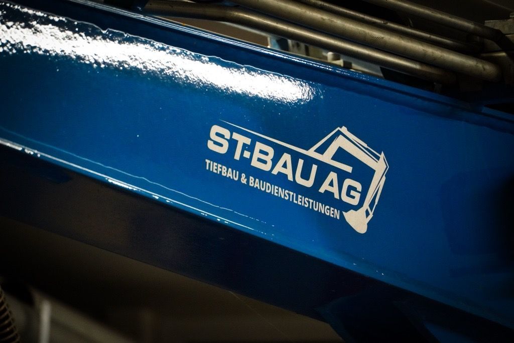 Ein Haus wird mit einem blauen Bagger abgerissen. Foto von der ST-Bau AG