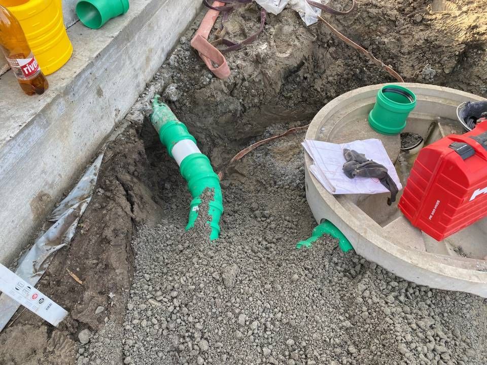 Ein Gullydeckel wird in die Erde eingebaut. Foto von der ST-Bau AG