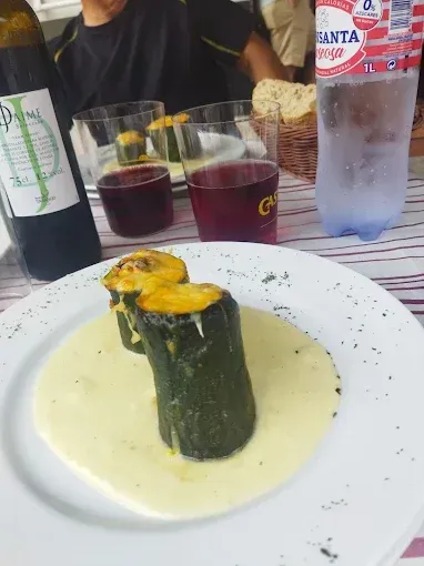 Un plato de comida con una botella de agua Fanta al fondo.