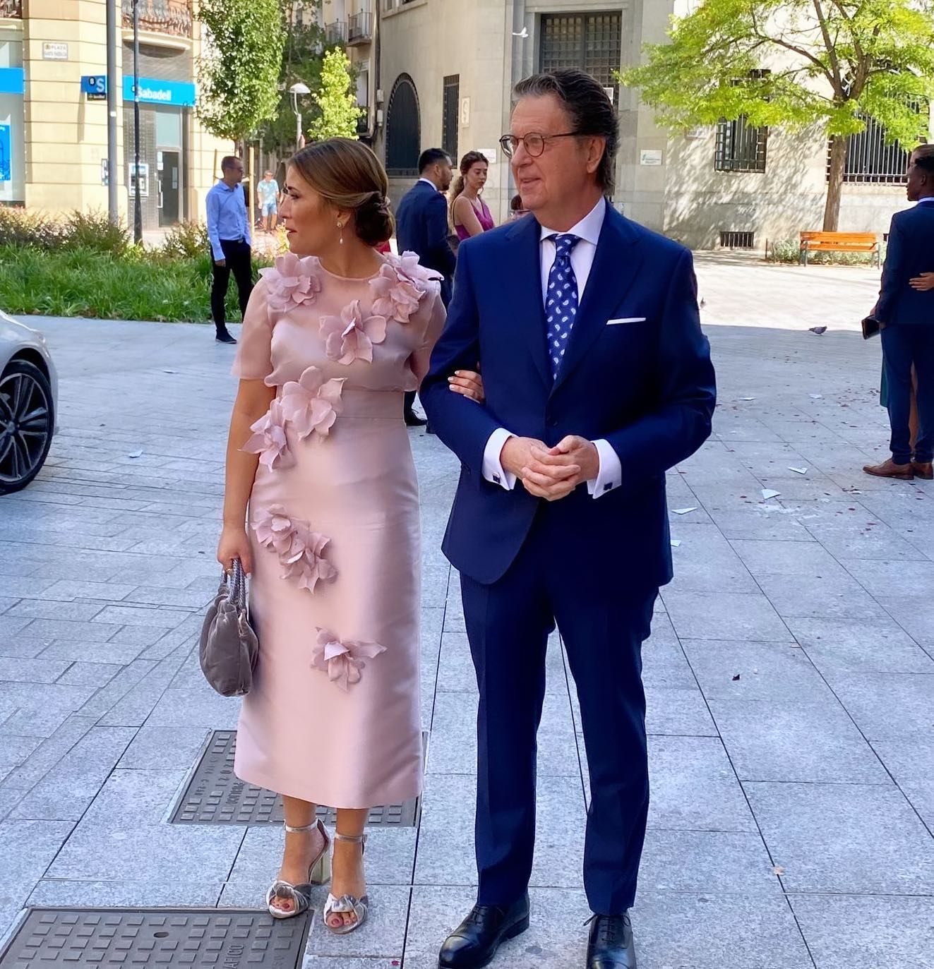 Un hombre con traje y corbata está junto a una mujer con un vestido rosa.