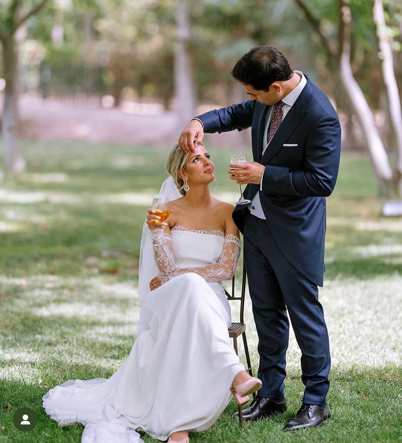 Una novia y un novio posan para una foto en el césped.