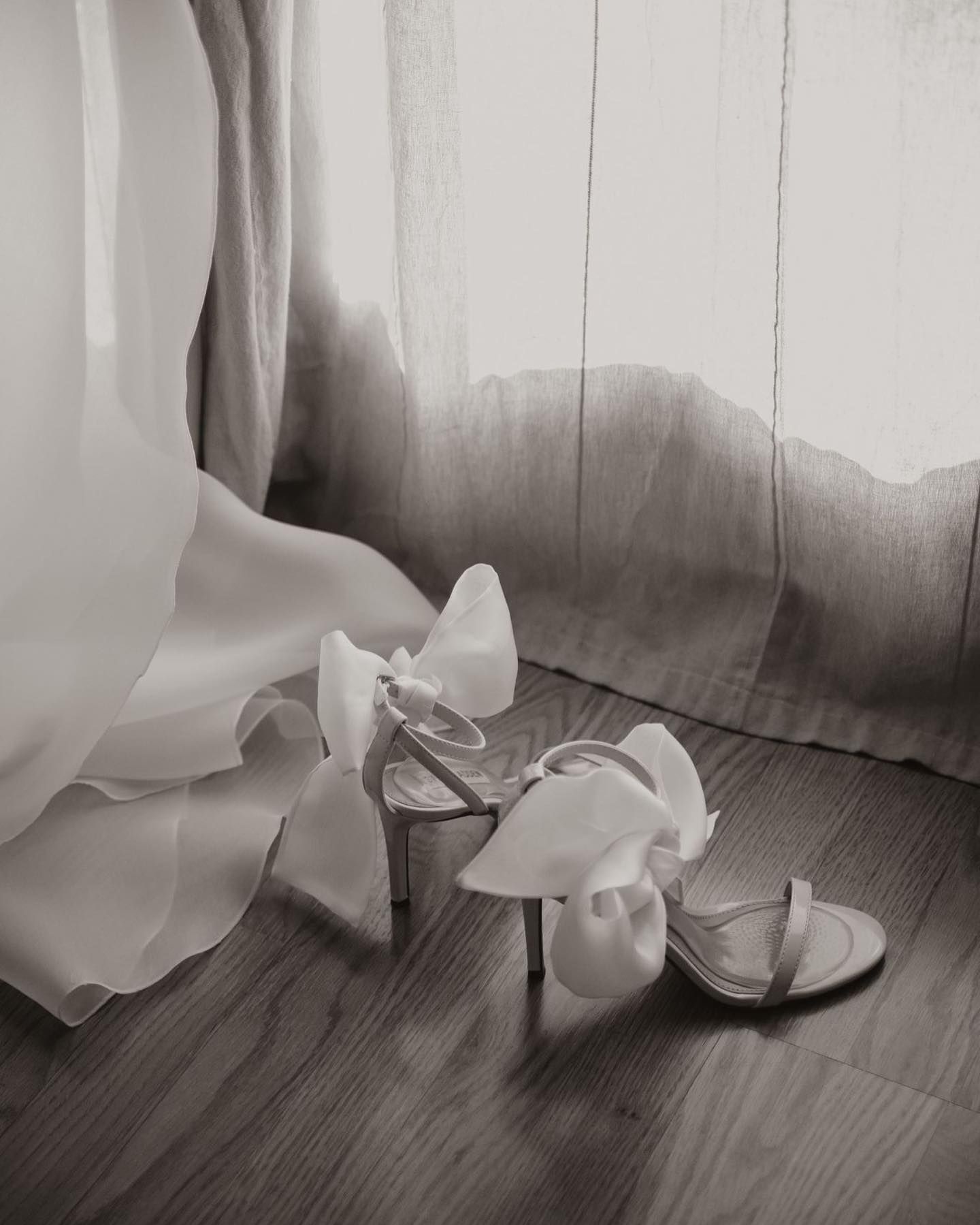 Una foto en blanco y negro de los zapatos de boda de una novia en el suelo.