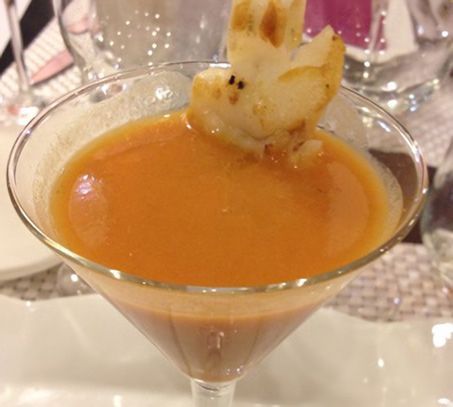 Una copa de martini con un camarón encima.