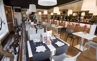 Un restaurante con muchas mesas y sillas