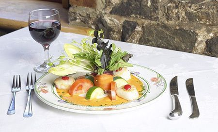 Un plato de comida y una copa de vino en una mesa