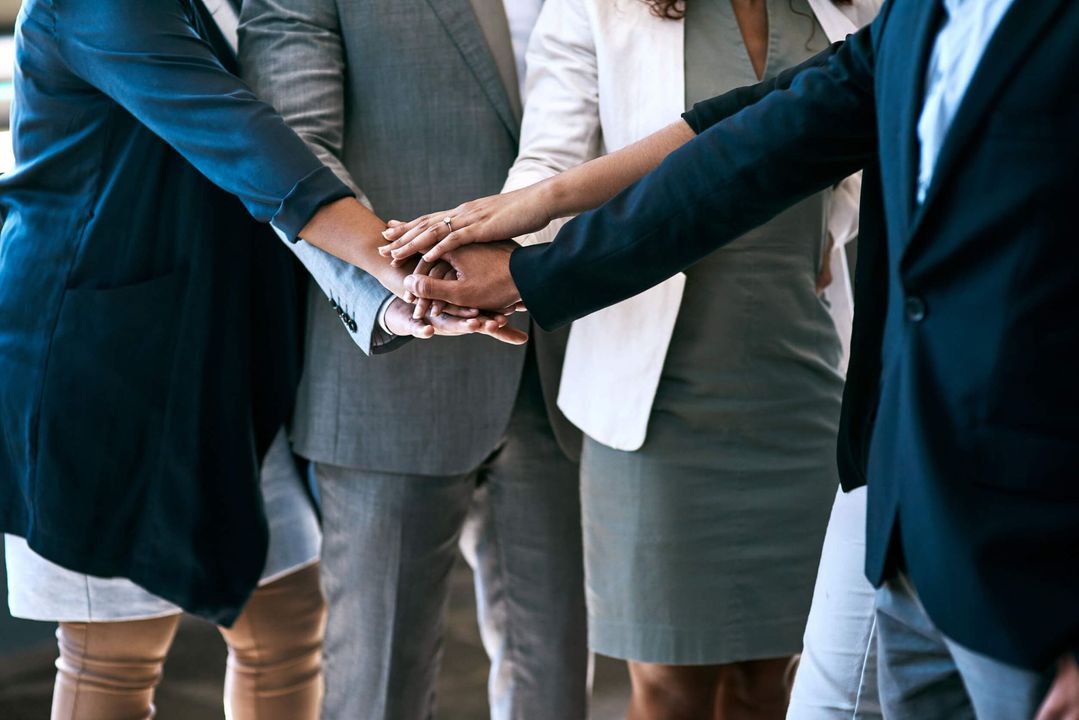 Un grupo de hombres de negocios juntan sus manos.