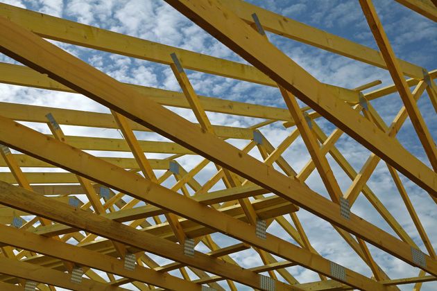 Des fermes de toit en bois jaune sur fond de ciel bleu