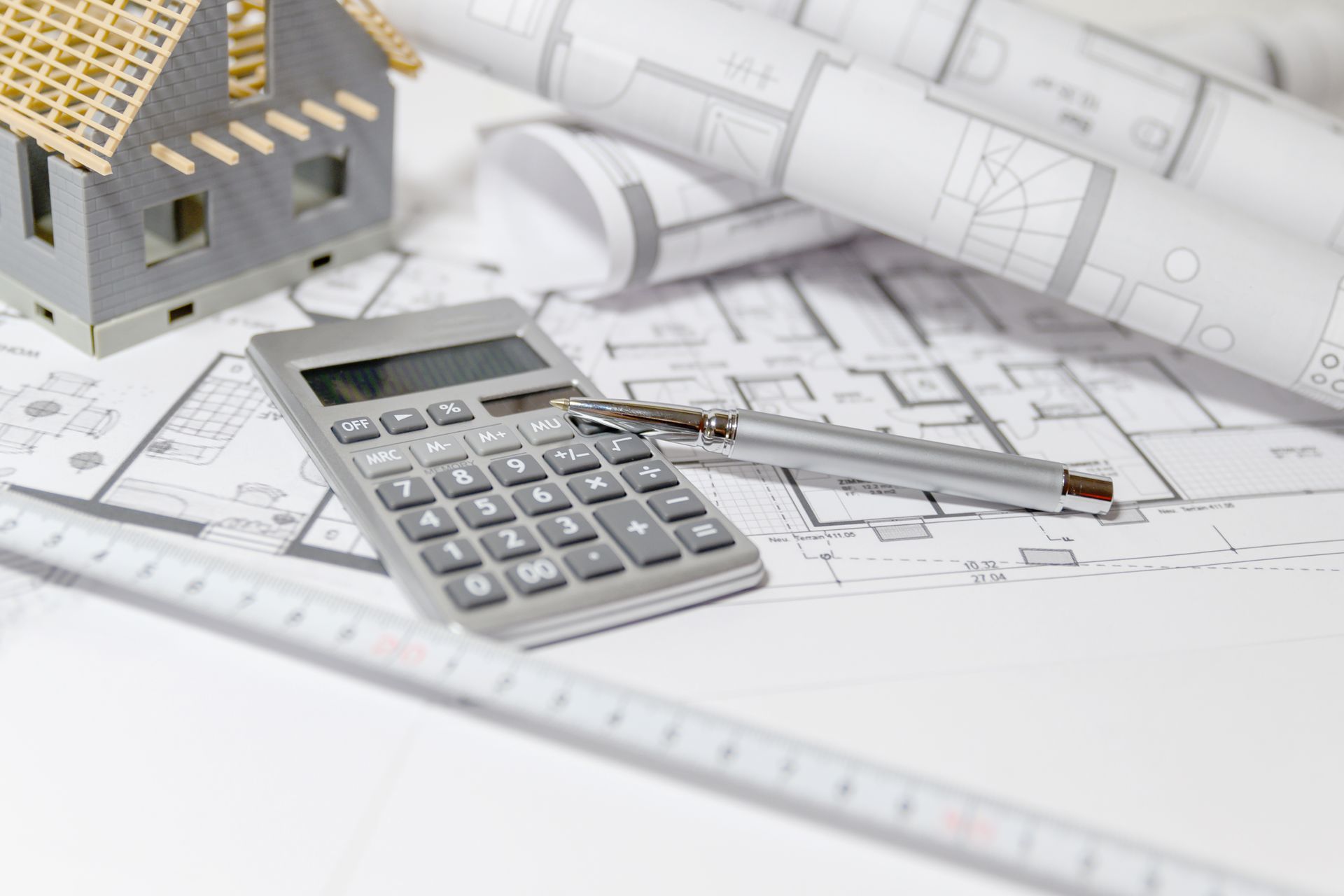 Calculatrice, outils de dessin et maquette de maison sur les plans architecturaux