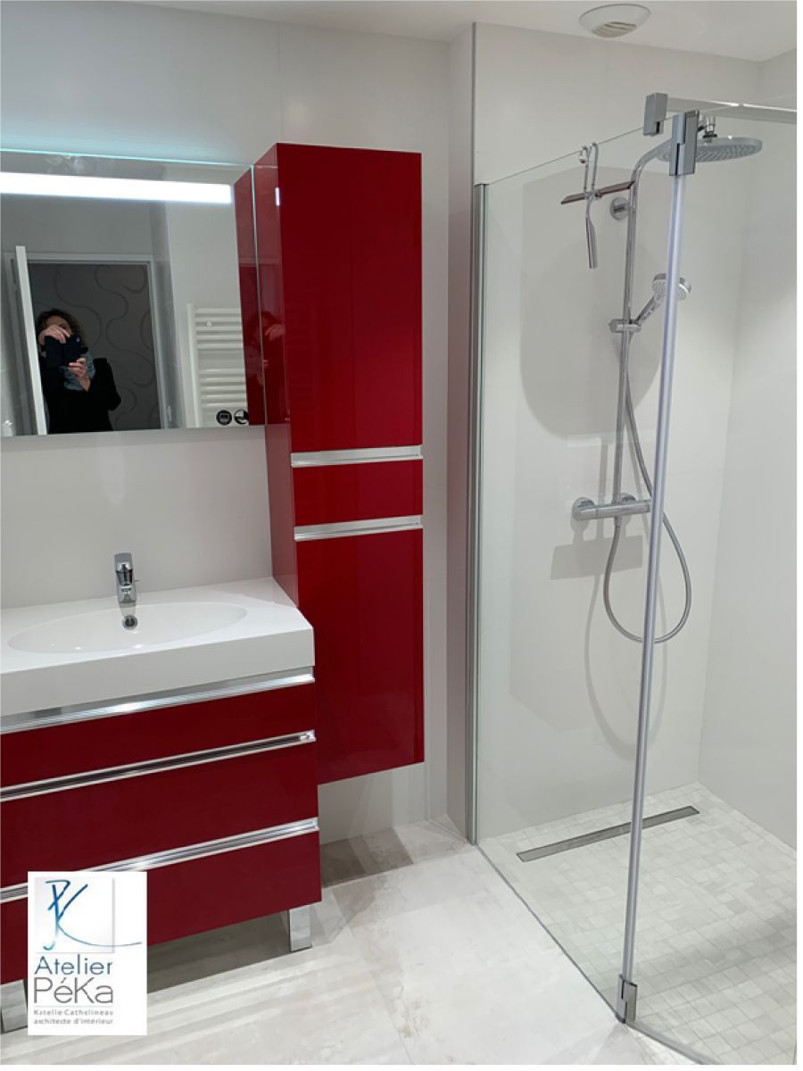 Salle de bains moderne avec meuble-lavabo, miroir, lavabo et douche à l'italienne avec barre d'appui et siège de douche.