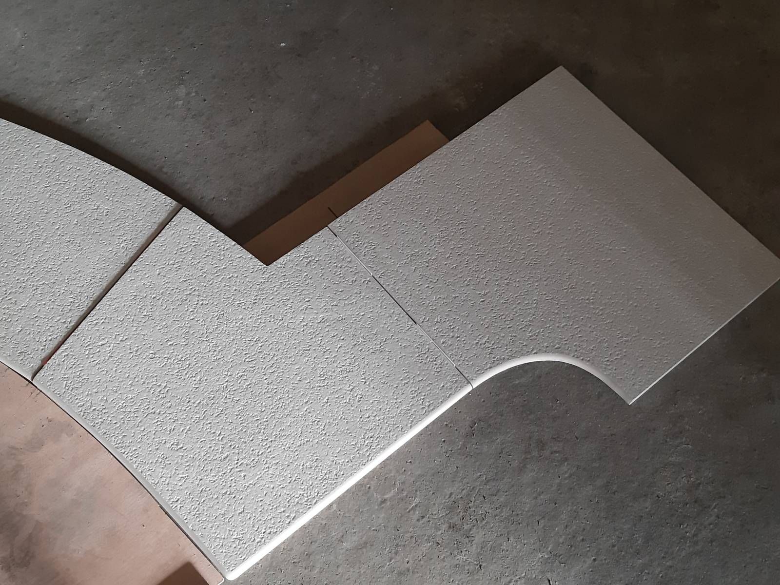 Dalle de pierre mouchetée avec une découpe incurvée sur une surface de pierre.