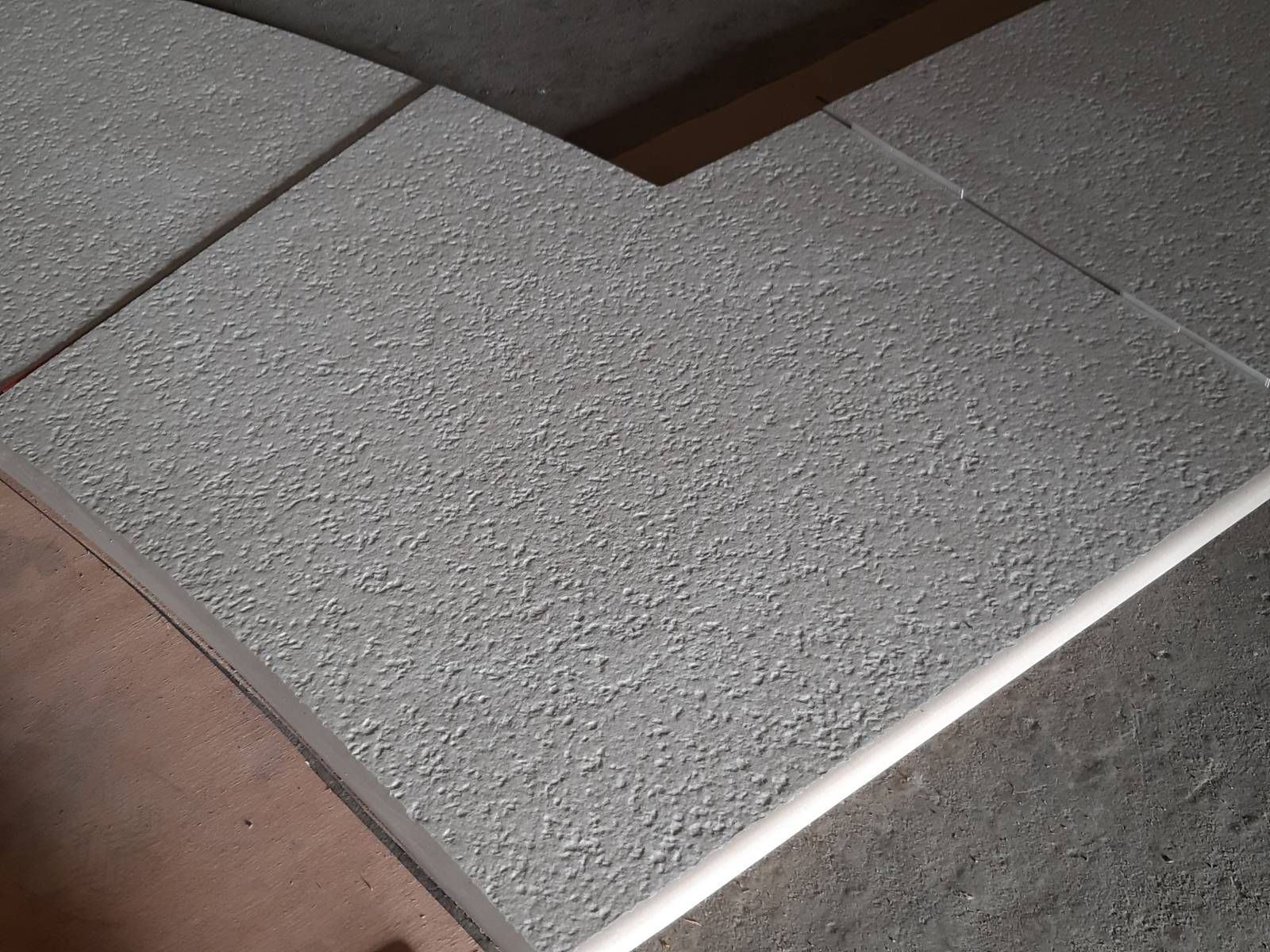 Gros plan d'une dalle de pierre texturée aux bords biseautés sur une surface.