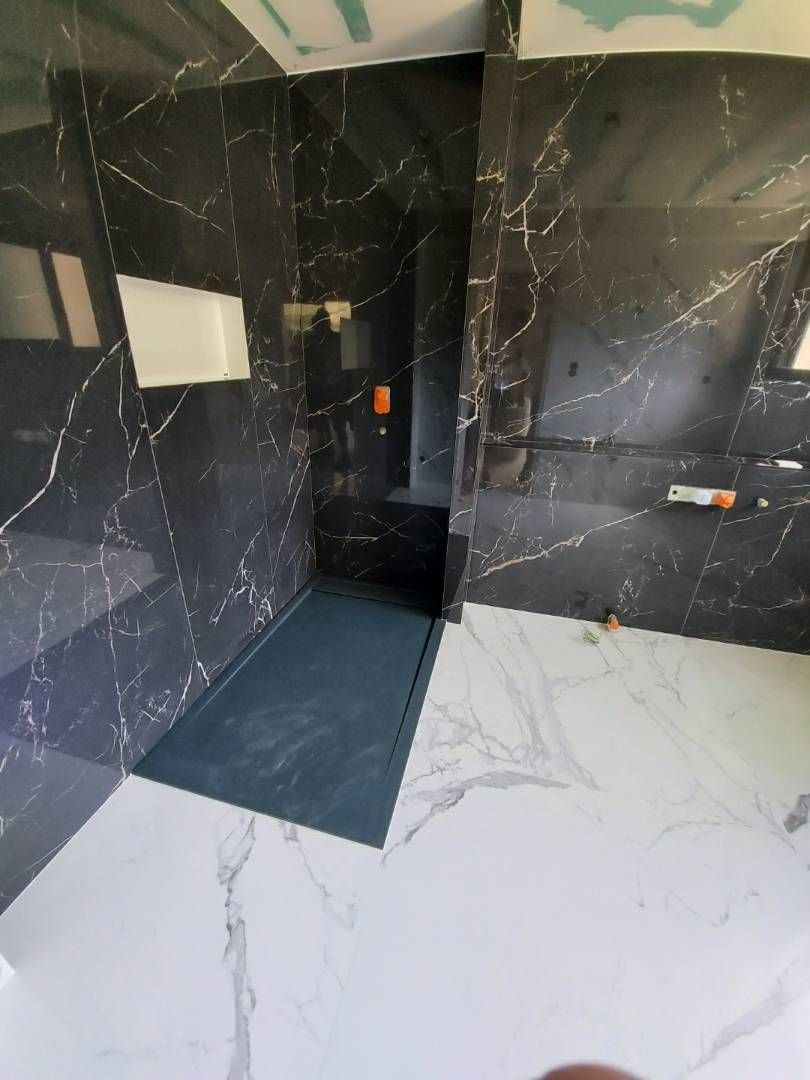 Salle de bains moderne avec murs en marbre, sol en marbre et douche à l'italienne.