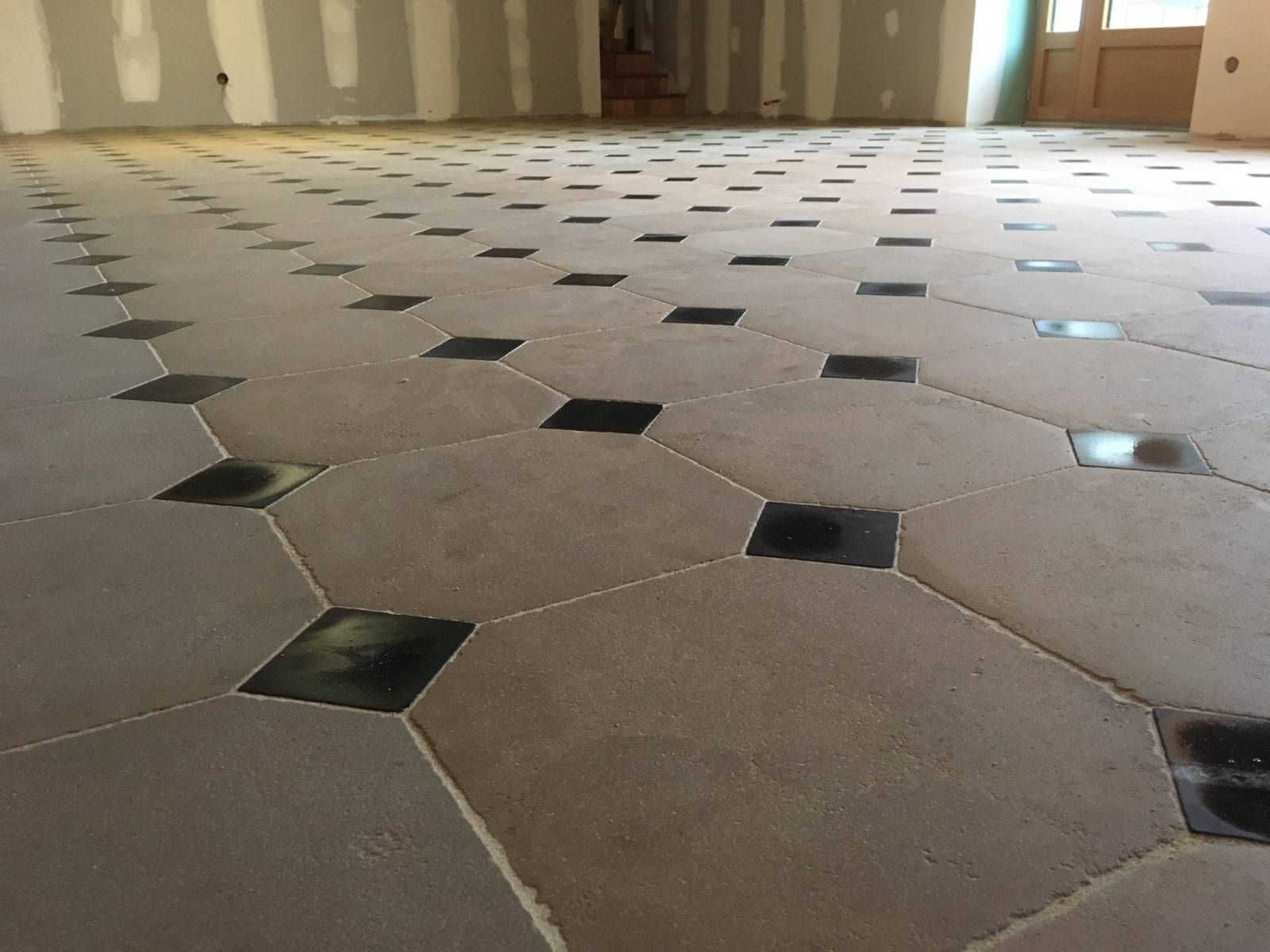 Grand sol carrelé avec de petits accents de losanges dans une pièce.