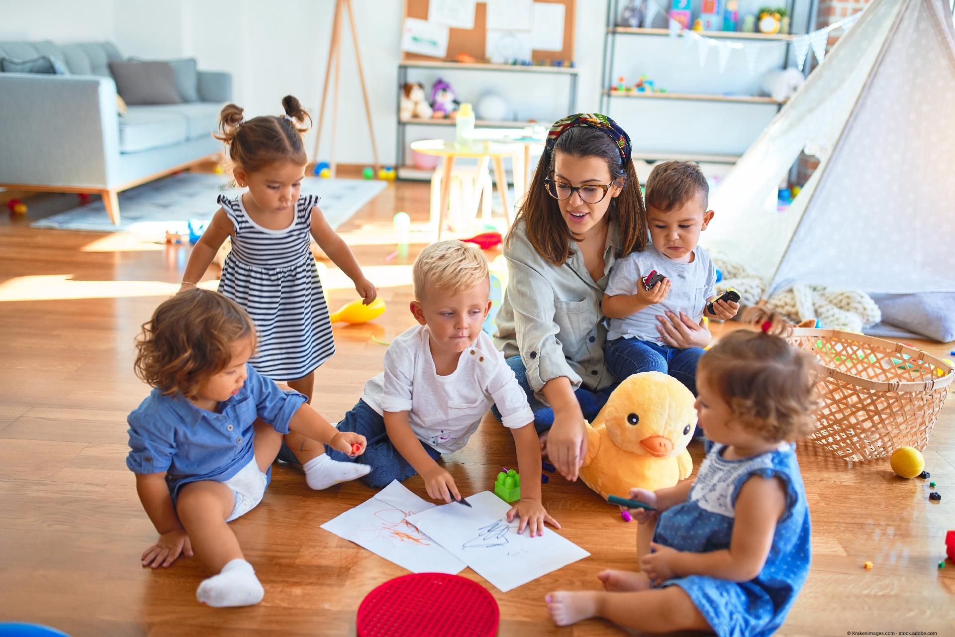 Kinderspielgruppe sitzt zusammen und malt