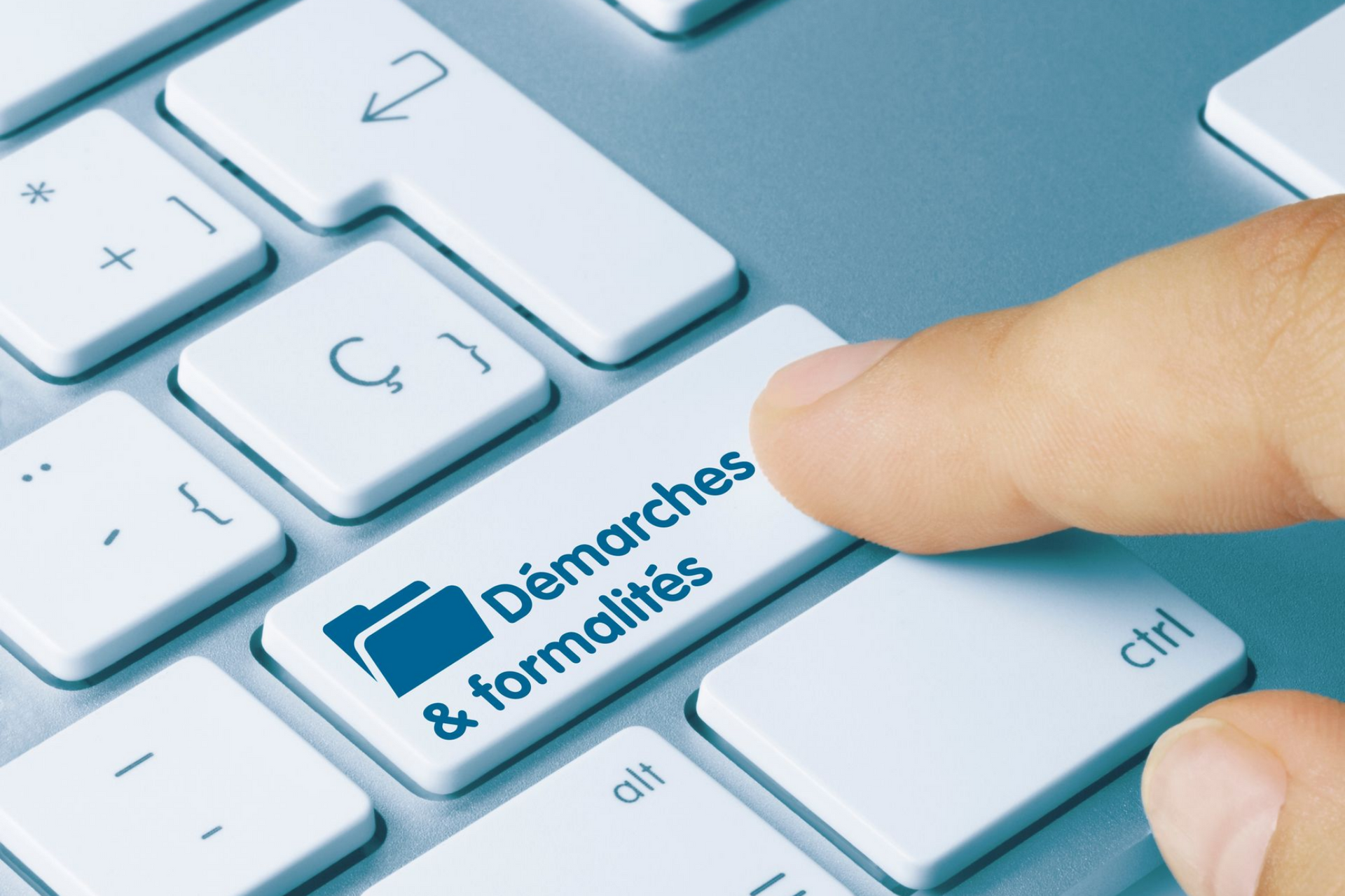 Finger pressing keyboard key labeled “Démarches & formalités”