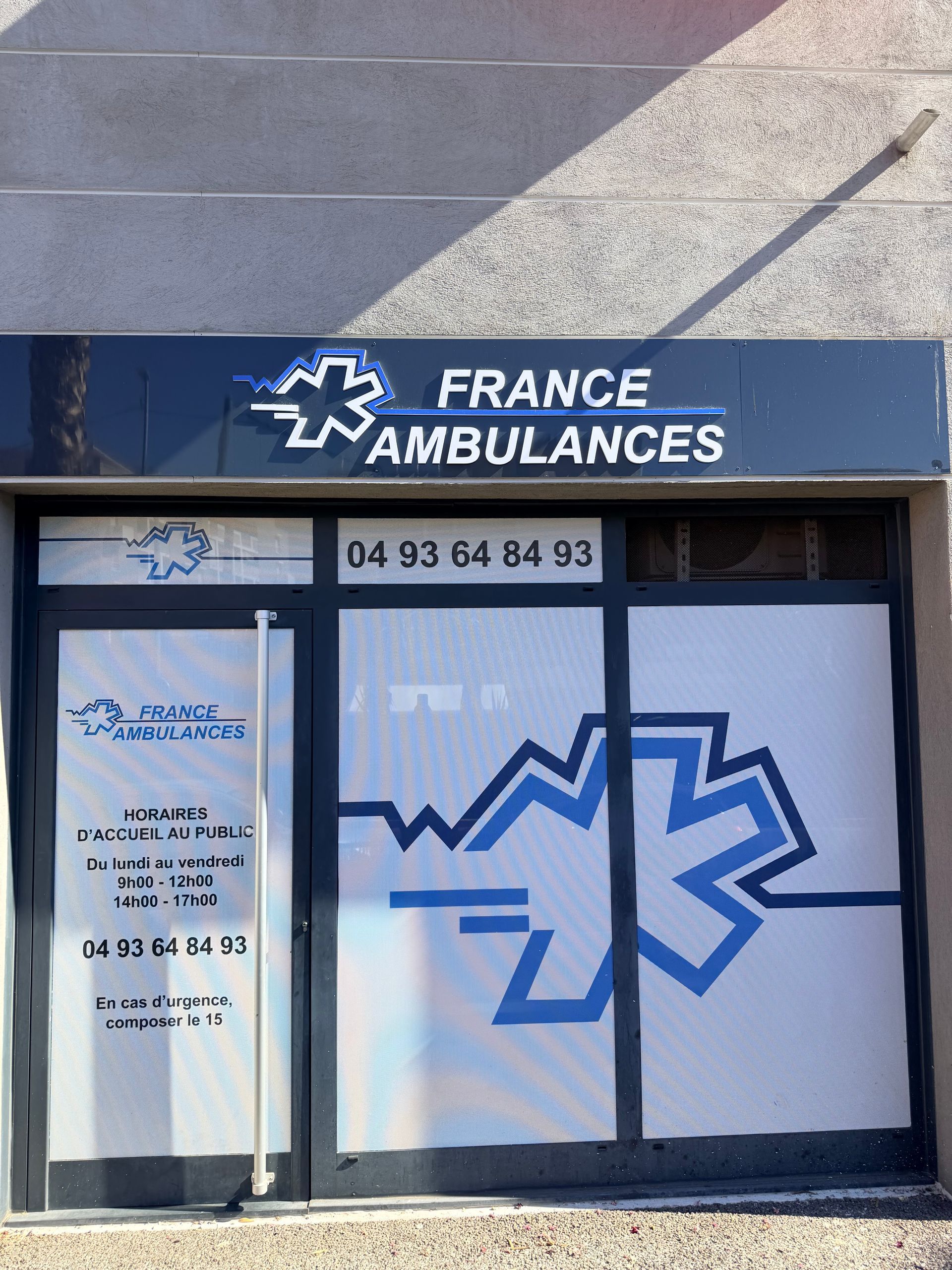 Vitrine de France Ambulances avec logo médical en forme d'étoile bleue et numéro de téléphone en vitrine