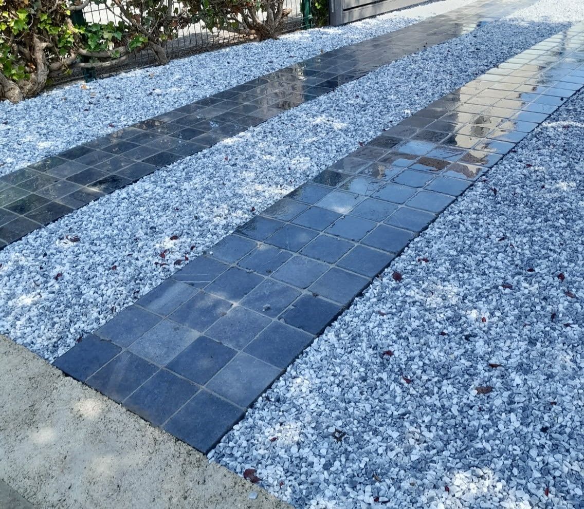 Allées en carreaux carrés foncés flanquées de gravier bleu clair