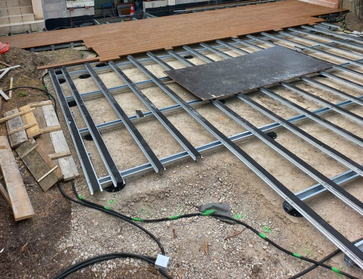 Structure métallique avec bandes noires et platelage composite marron partiellement installé