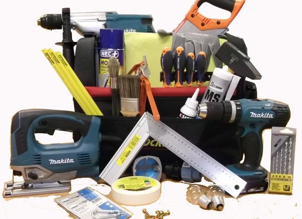 Assortiment d'outils de construction dans un sac noir ; comprenant une perceuse, une scie et des tournevis, sur une surface blanche.