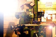 Una máquina está sentada frente a una pared de ladrillos en una fábrica.