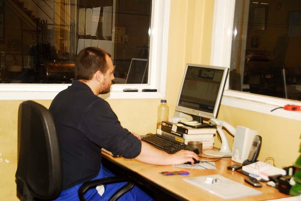 Un hombre está sentado en un escritorio usando una computadora.