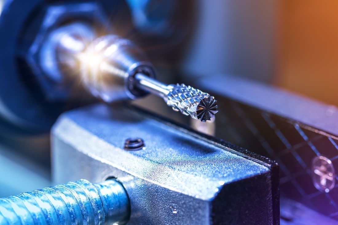 Un primer plano de una máquina que está cortando un trozo de metal.