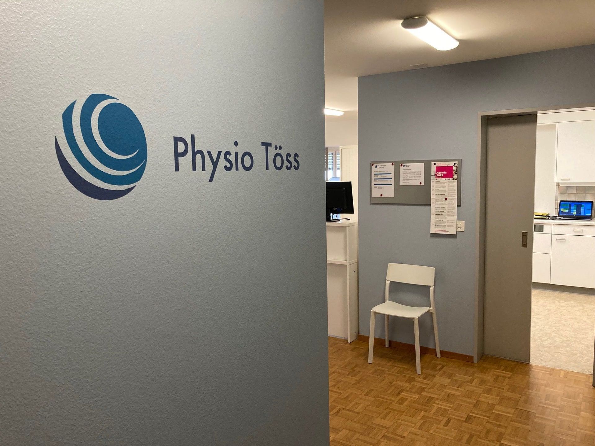 Ein Raum mit einem Stuhl und einem Schild mit der Aufschrift „Physio Toss“