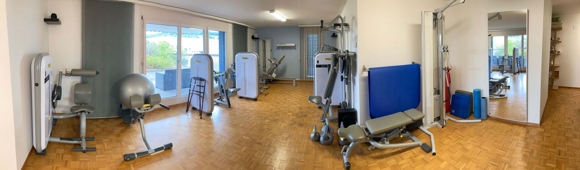 Ein großer Raum mit vielen Trainingsgeräten.