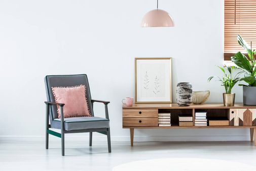 Modern eingerichtetes Wohnzimmer mit Sessel und Kommode