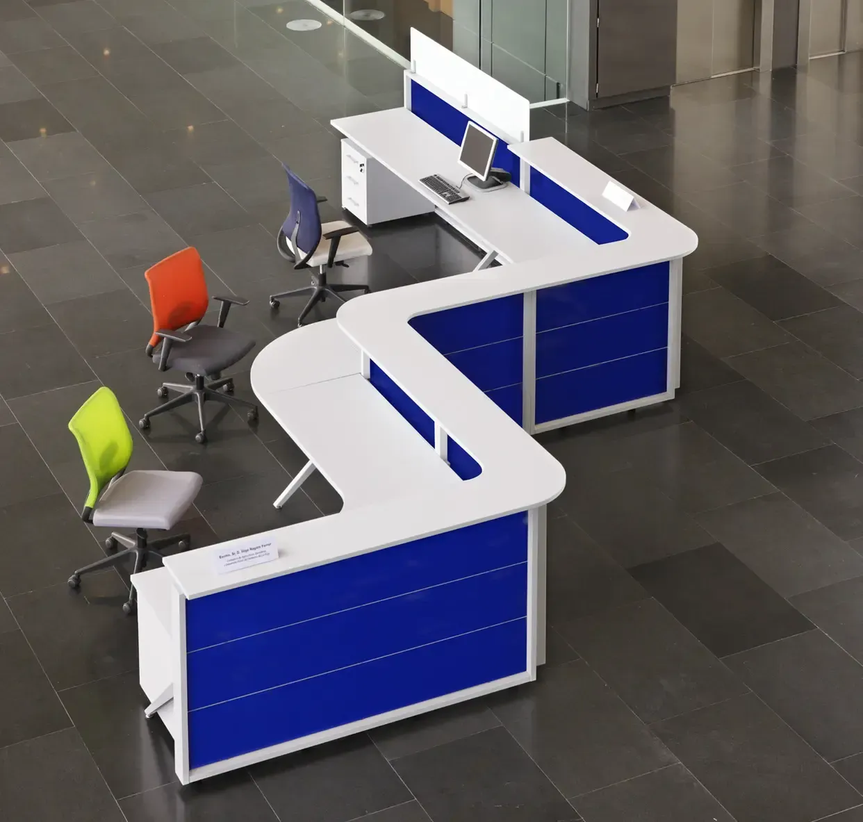 Escritorios de oficina modernos en disposición zigzag azul y blanco con sillas de colores.