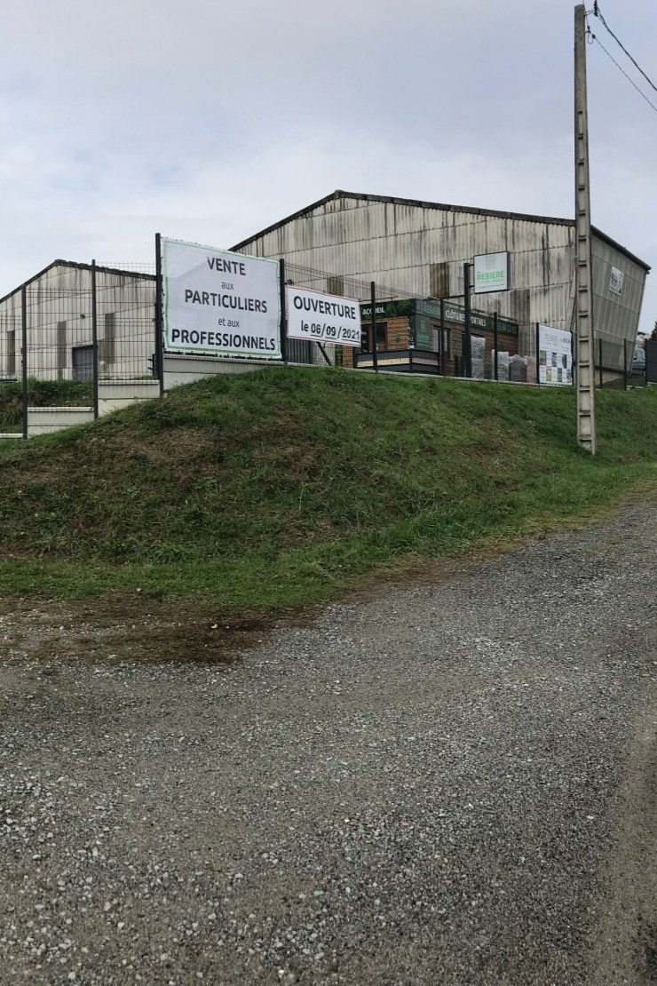 Un bâtiment avec des panneaux sur une colline, probablement un magasin de fournitures de plomberie.