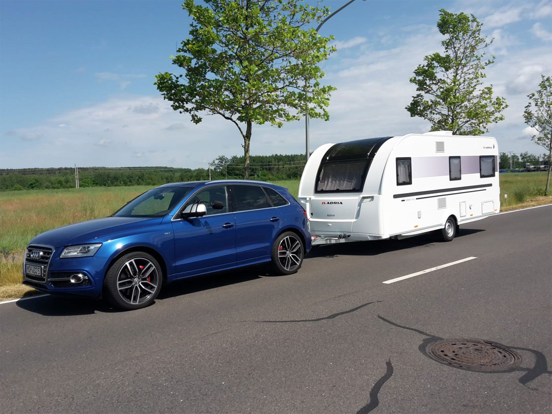 Blaues Auto mit Wohnwagen