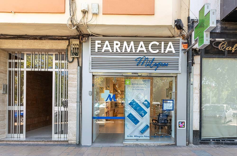 Una farmacia con una cruz verde al costado.