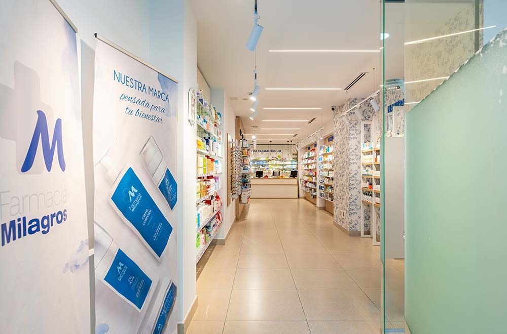 Un largo pasillo en una farmacia con un cartel que dice 'farmacia milagros'.