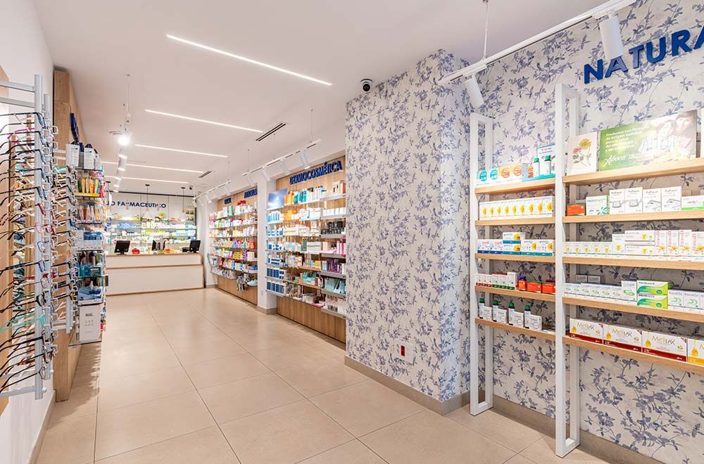 Una farmacia con muchos estantes y un mostrador.