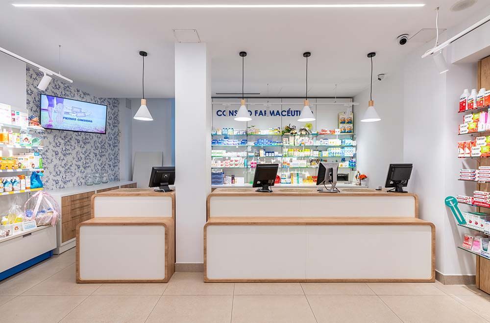 Una farmacia con dos mostradores y un televisor en la pared.