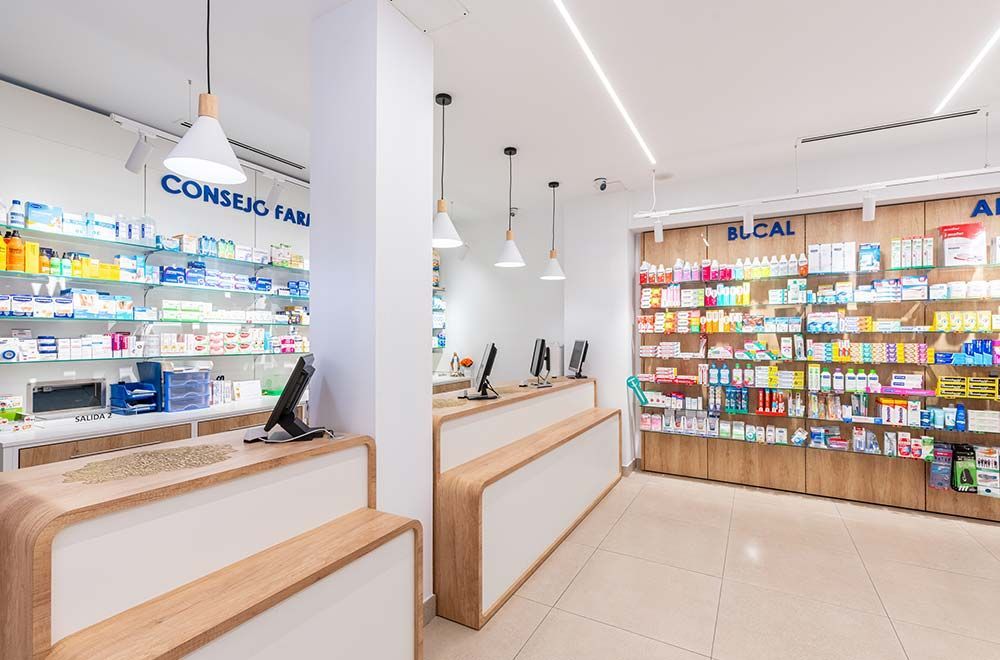 Una farmacia con muchos estantes y un mostrador.