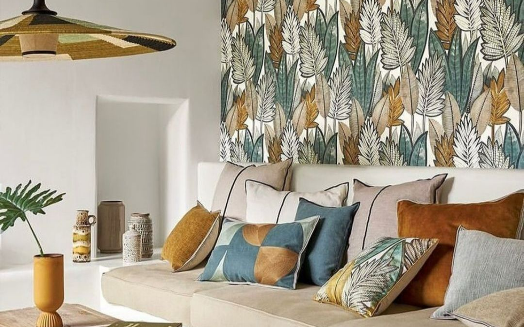 Canapé avec coussins devant mur avec papier peint même teinte que coussins