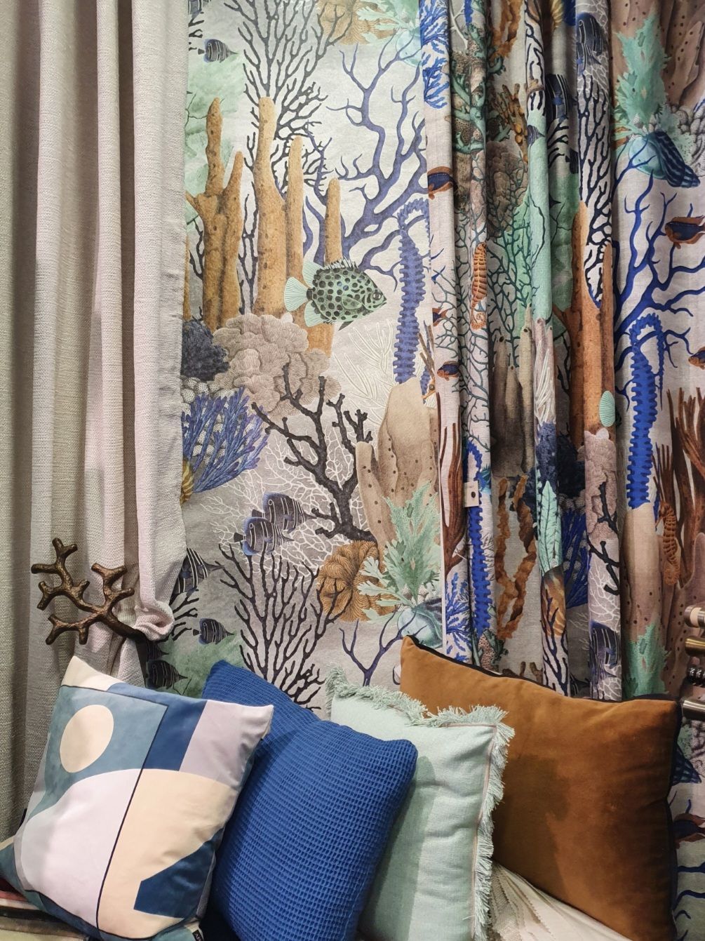 Coussins bleus marrons devant rideaux de même couleur