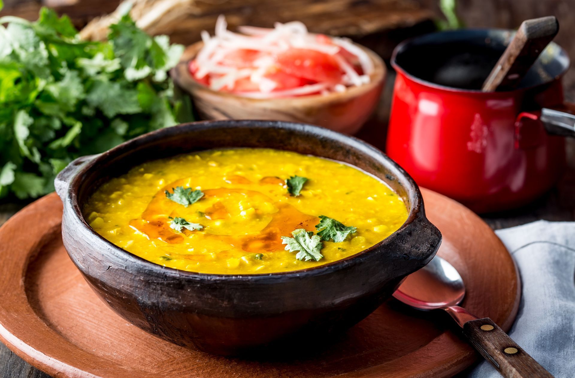 Un tazón de sopa con una cuchara dentro está en un plato.