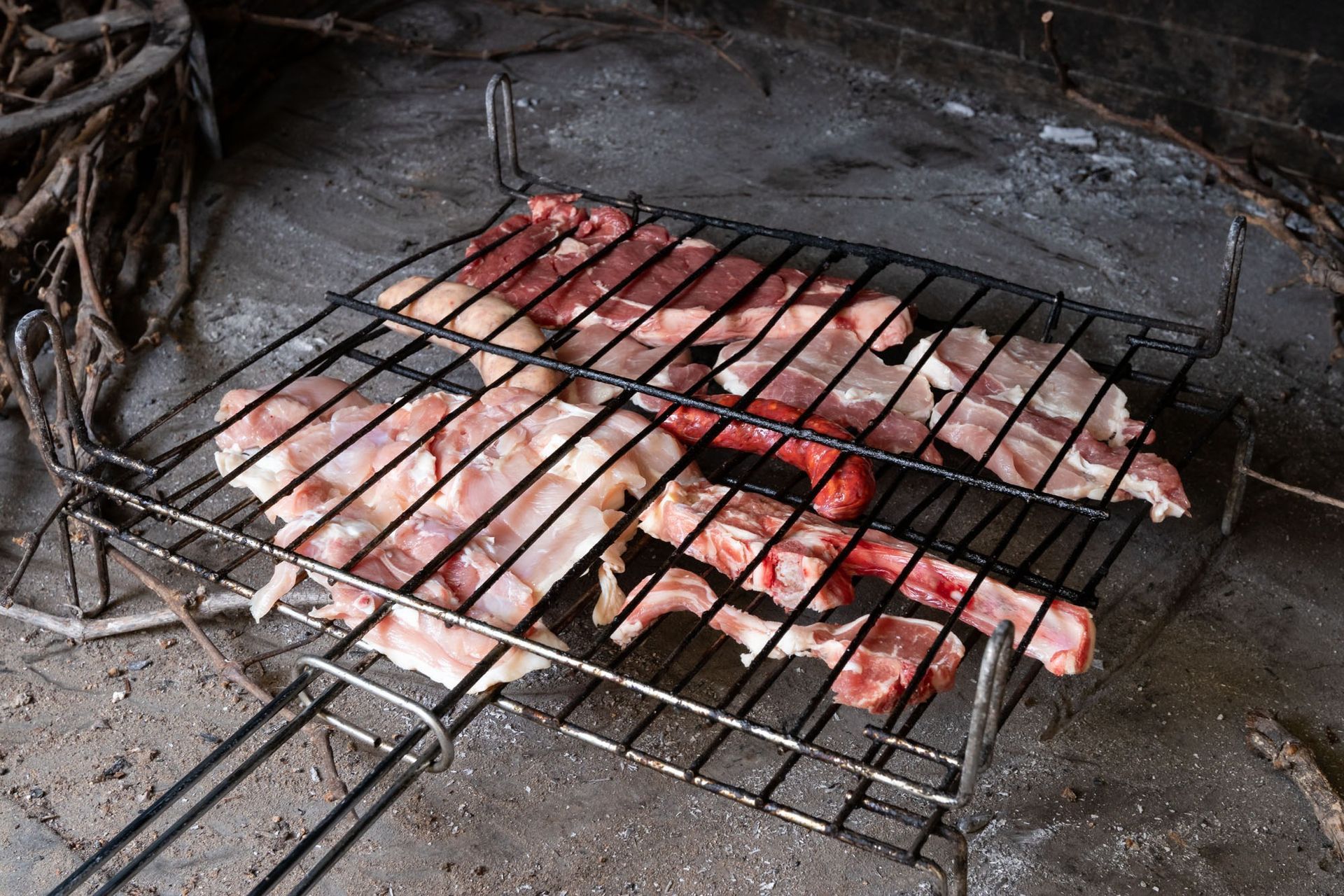 Un montón de carne se está cocinando en una parrilla