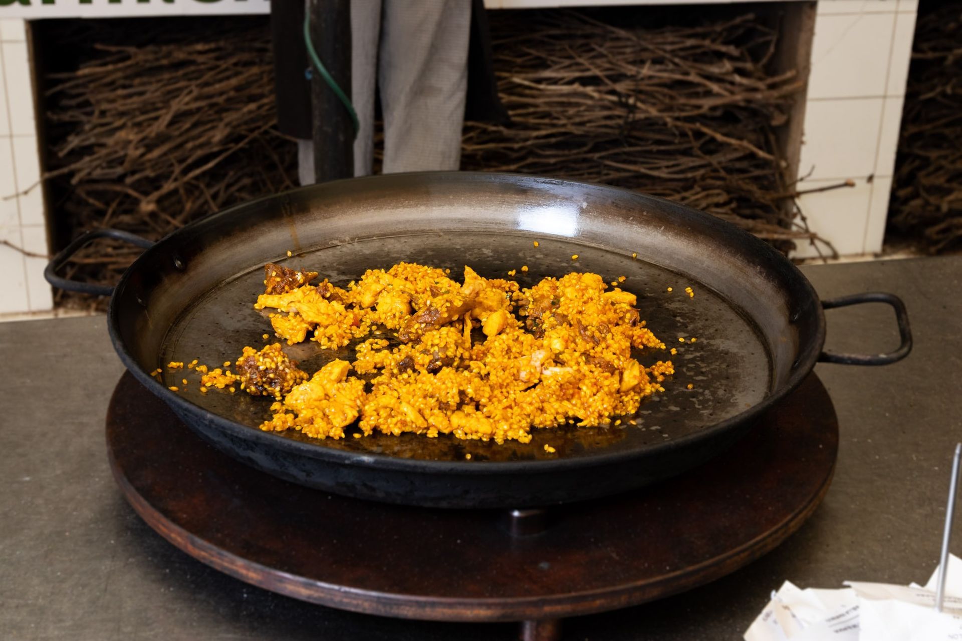 Una sartén con comida está sobre una mesa de madera.