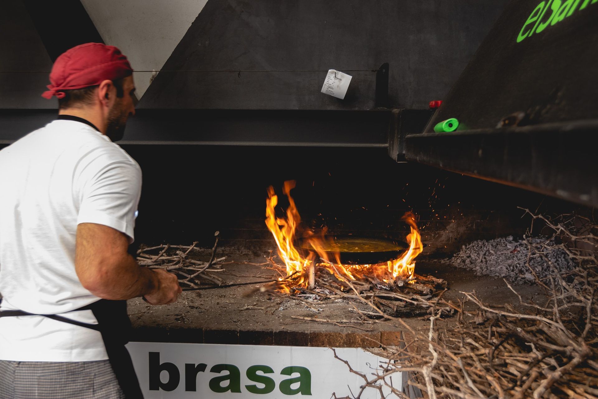 Un hombre está parado frente a un cartel que dice brasa